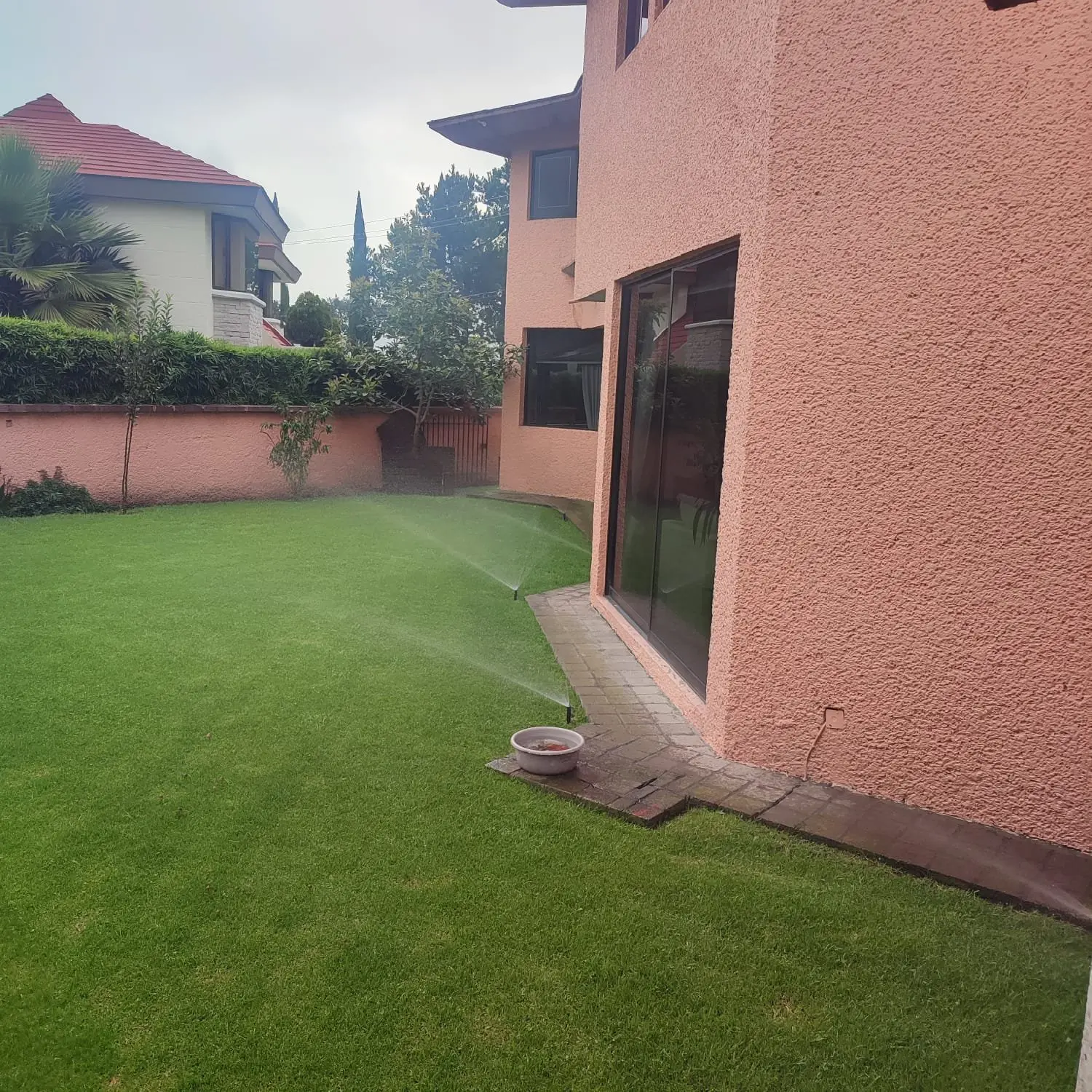 Aspersor en la franja de pasto junto a la casa